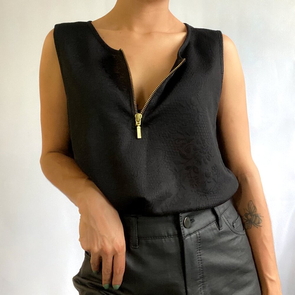 Black lace crop top with golden zipper.